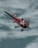 a red and white airplane in the sky