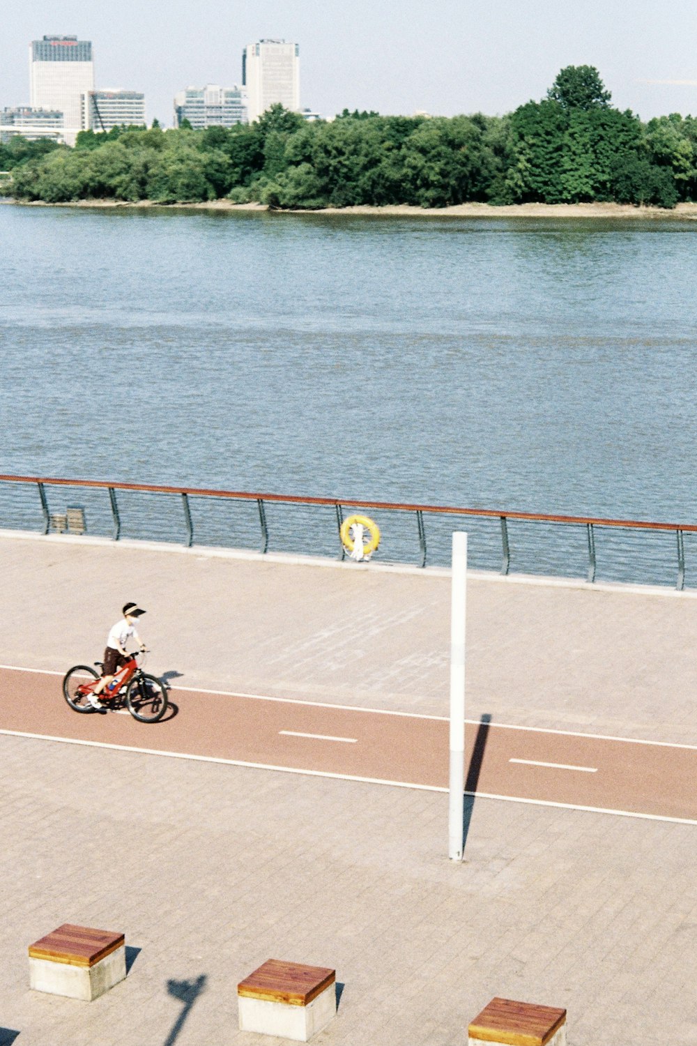 a person riding a bicycle on a road next to a body of water