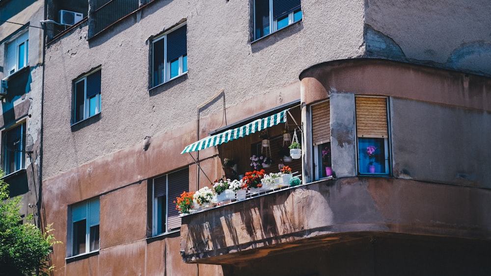 a building with a balcony and flowers