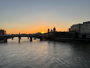 Sunset over the Vltava River with the iconic Charles Bridge silhouetted.