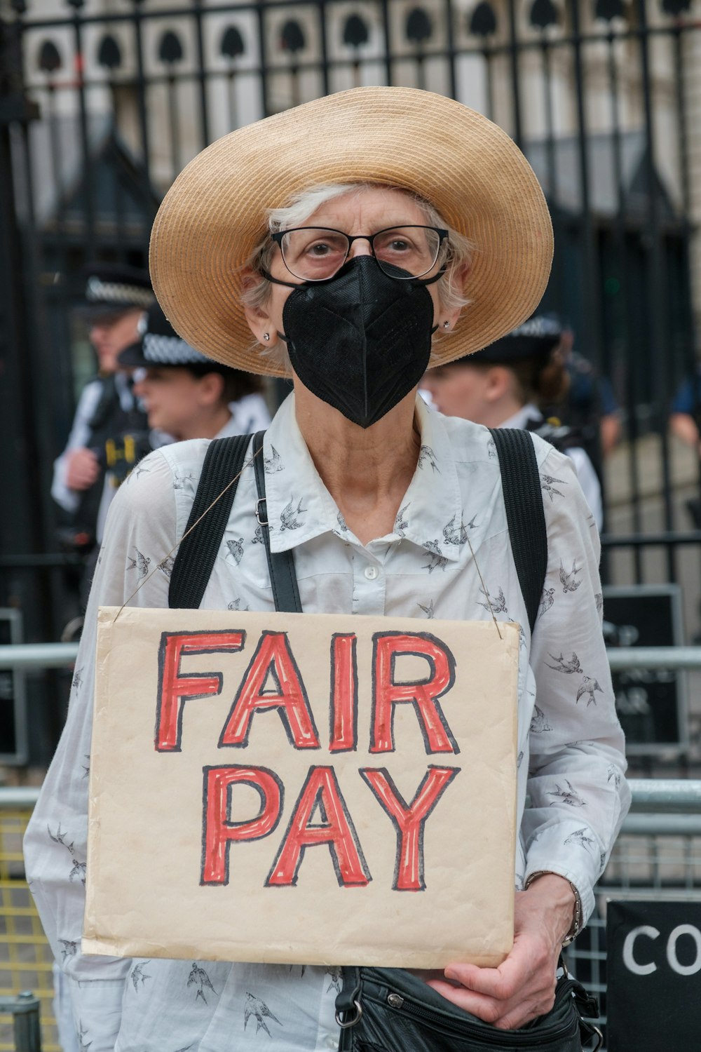 Un homme portant un chapeau et tenant une pancarte