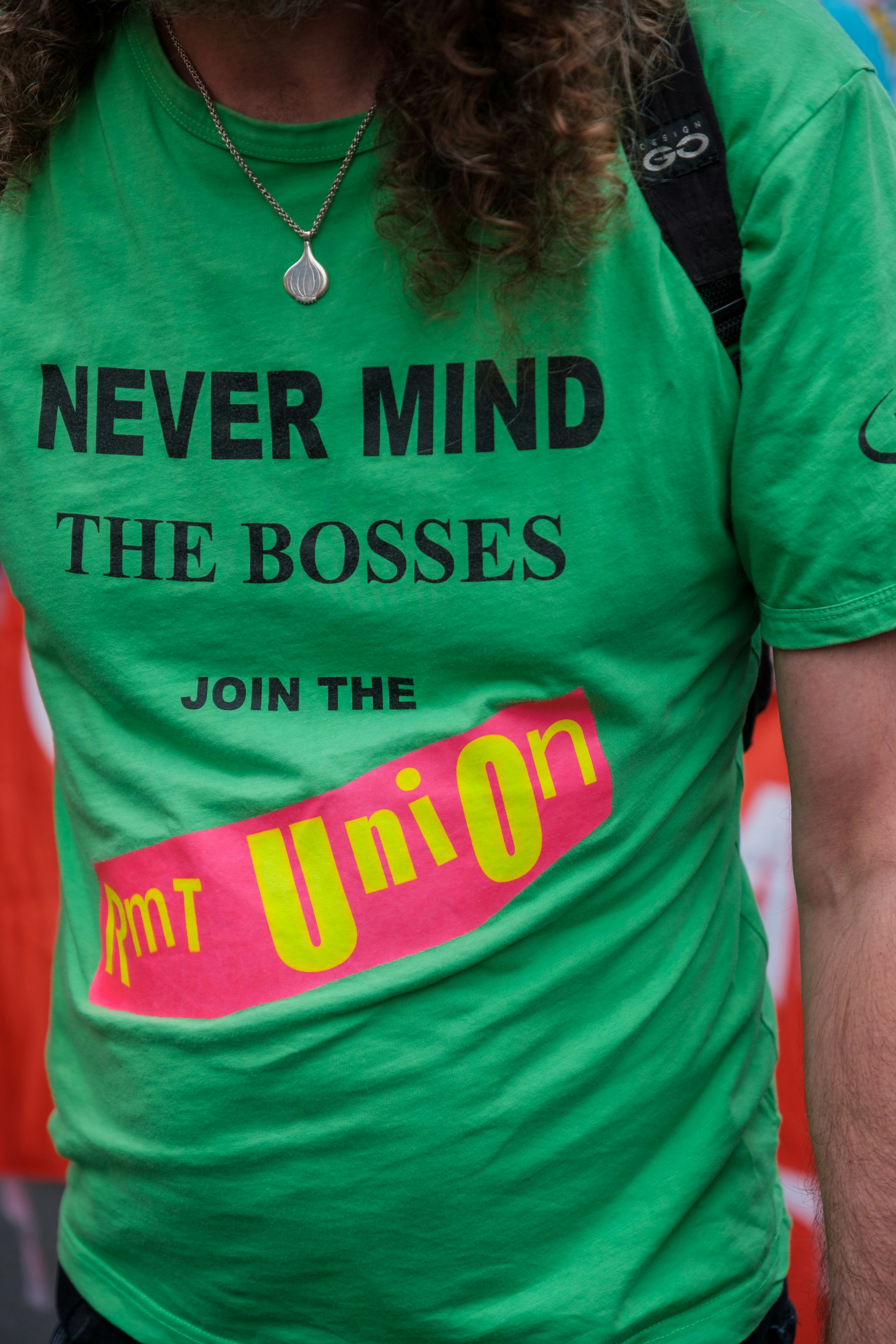 une personne portant une chemise verte avec un logo rouge et jaune