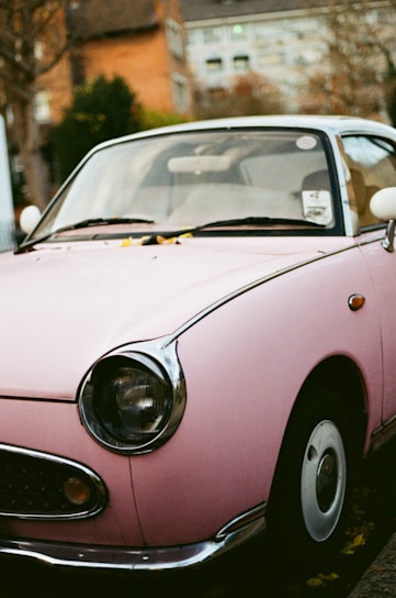 a pink car parked on the side of the road
