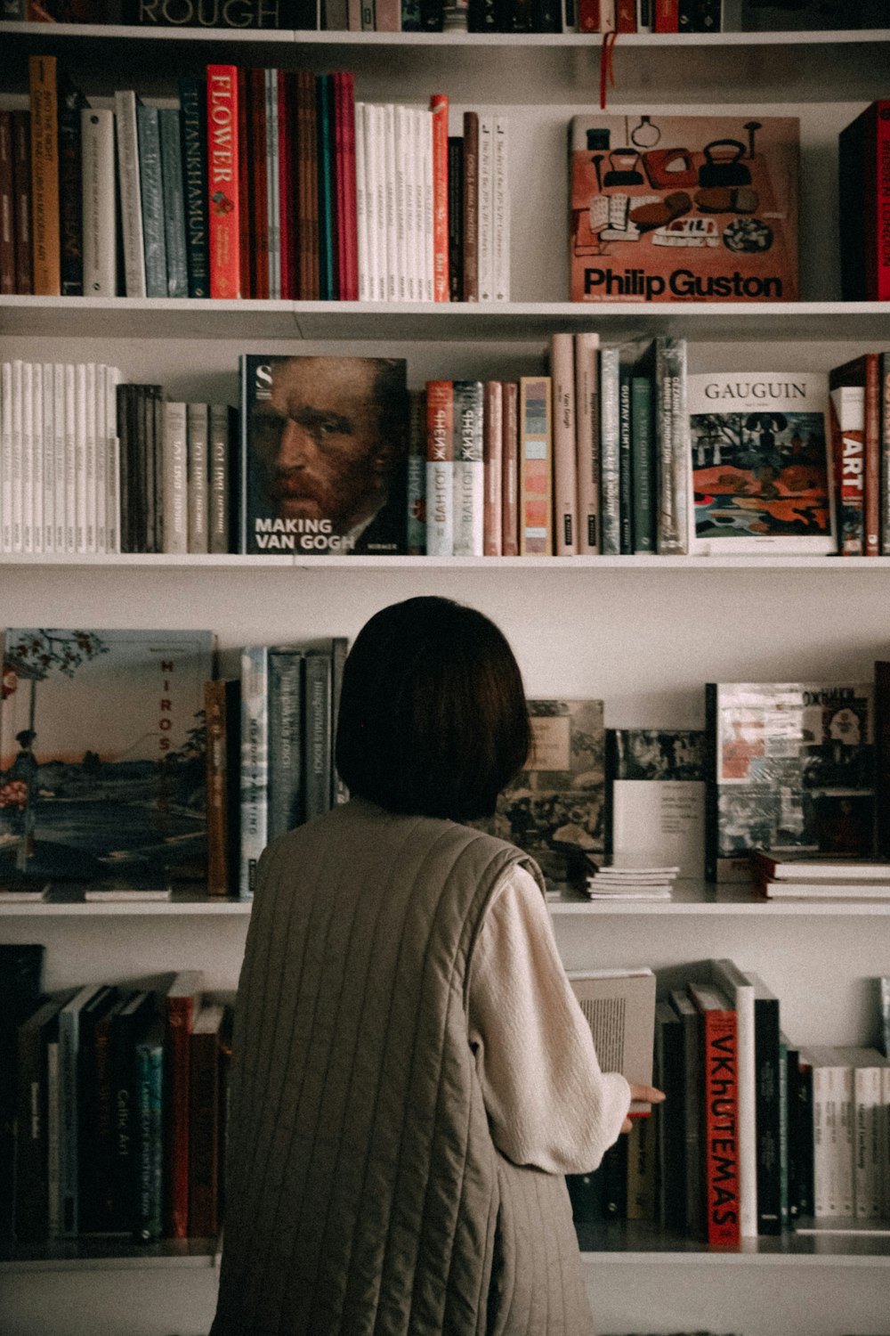 a person standing in front of a book shelf