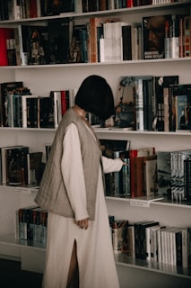 a person standing in front of a book shelf