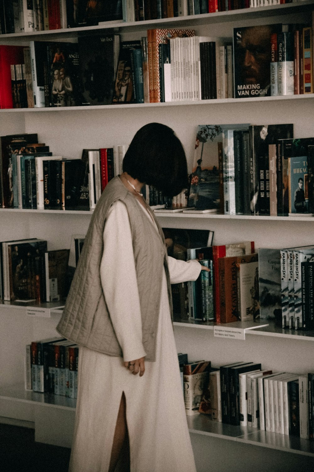 a person standing in front of a book shelf