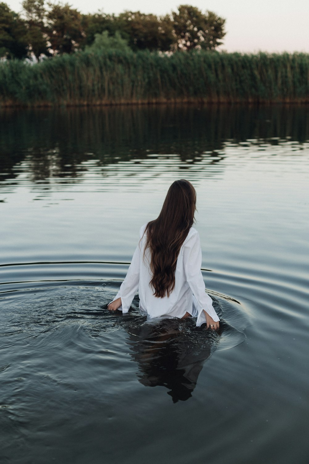 Una persona con un vestido blanco en un lago