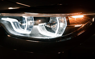 Close-up of a polished LED headlight casting a bright, focused beam.