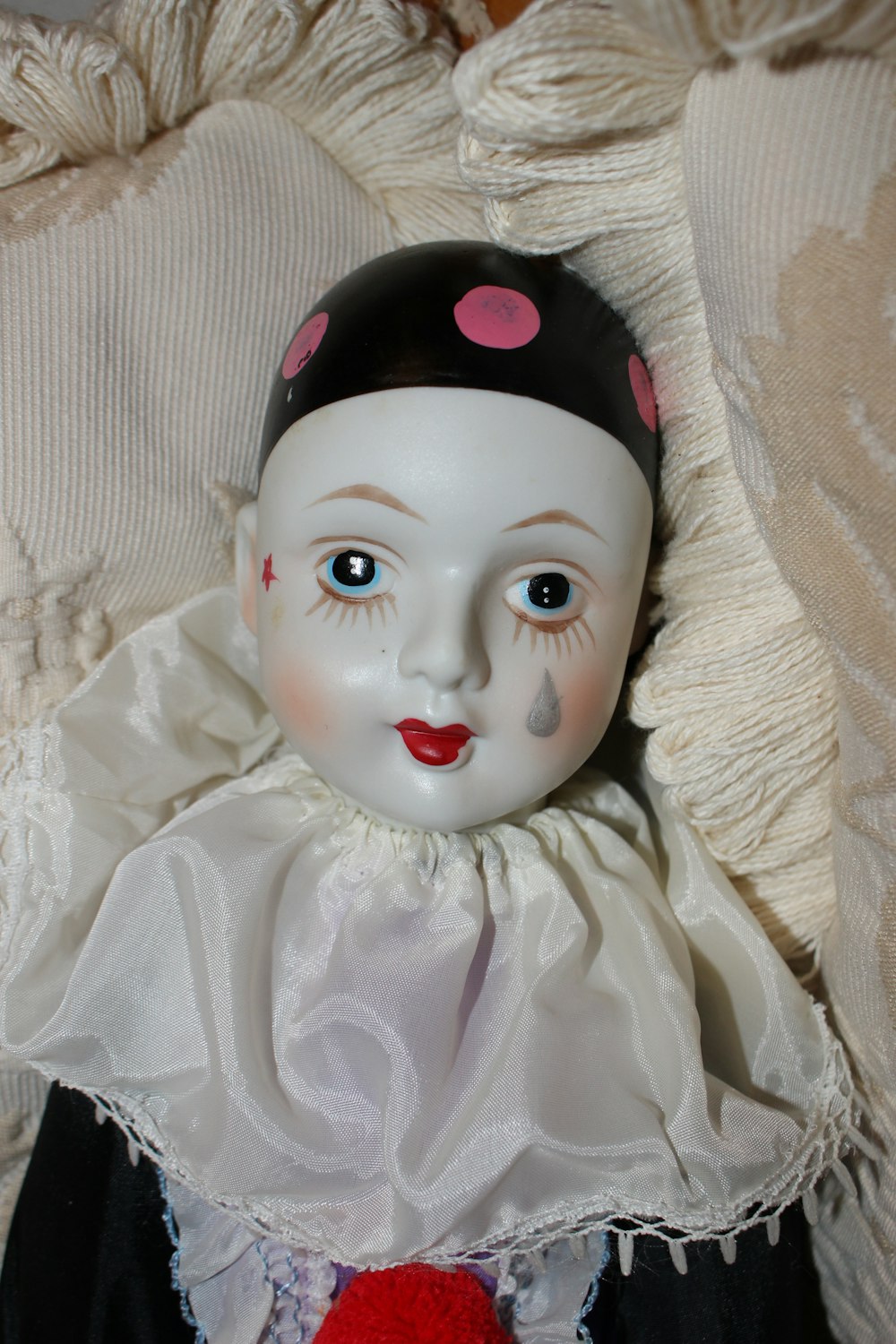 a white doll with a pink hat