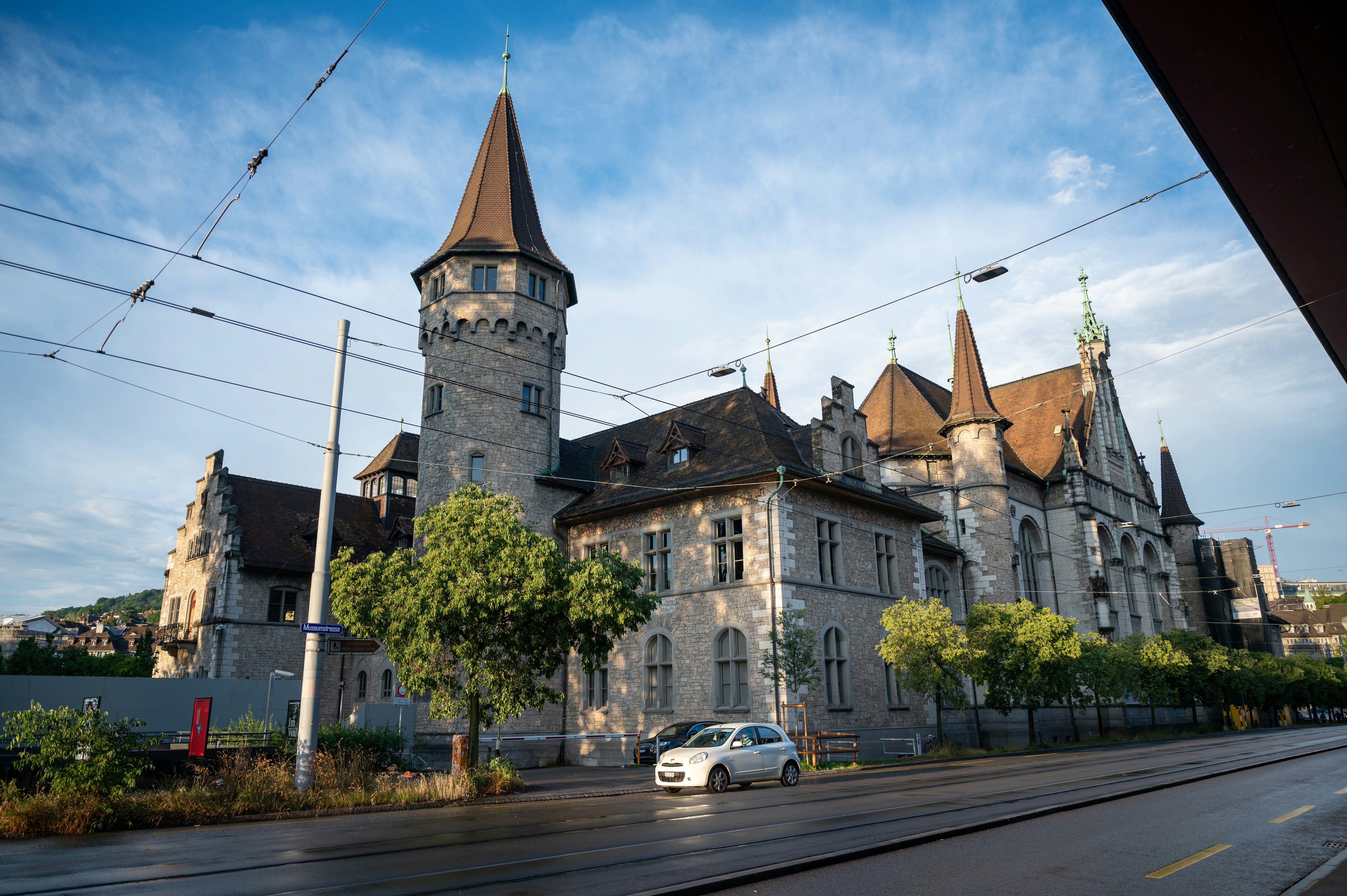 ETH Zurich university building exterior - a car driving down a road next to a large building