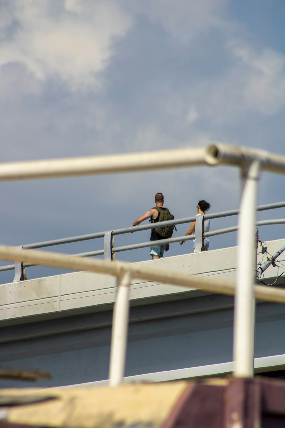 a couple of people walking on a bridge