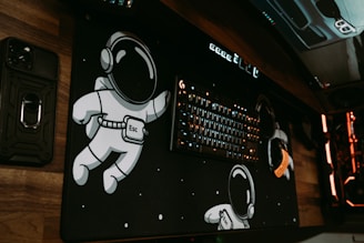 A cozy desk setup with nerdy posters, a gadget, and ambient RGB lighting