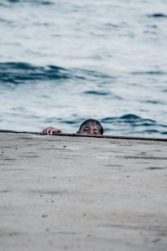 a person lying on a surfboard on a beach