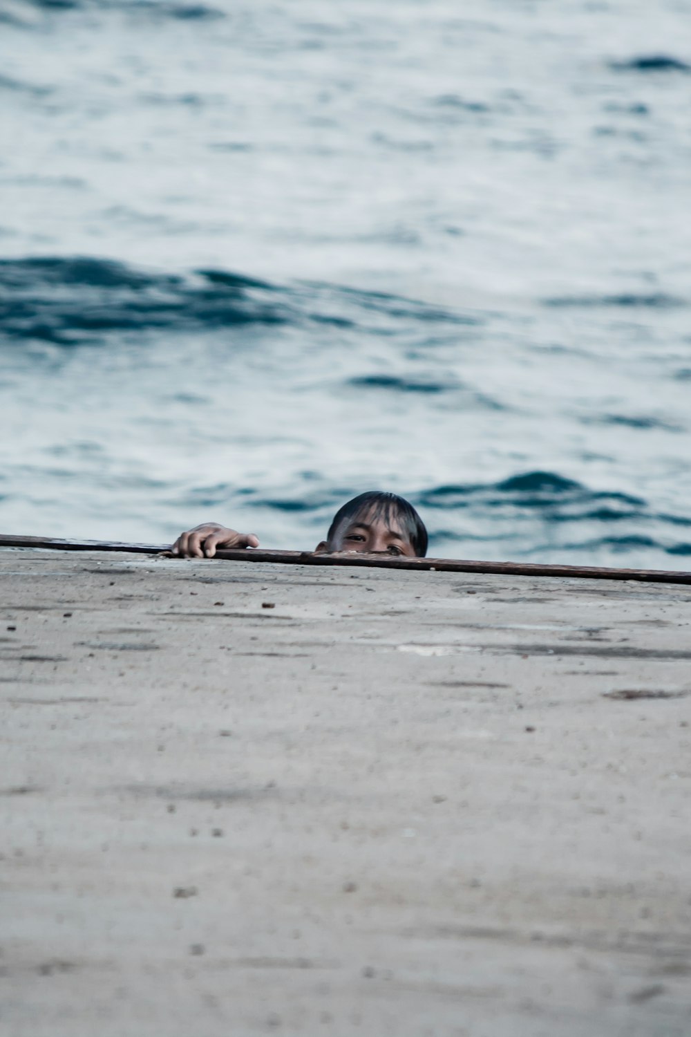 eine Person, die auf einem Surfbrett am Strand liegt