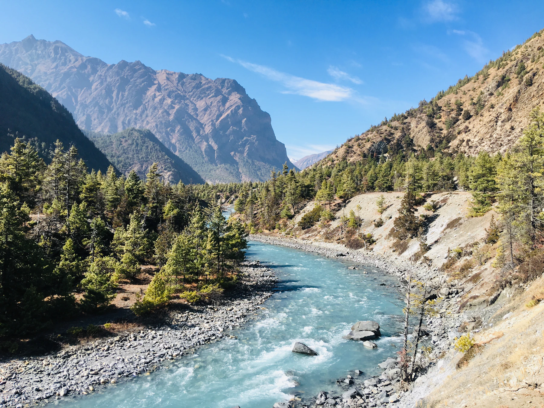 Turquoise river flowing through a forested mountain valley in Kalam