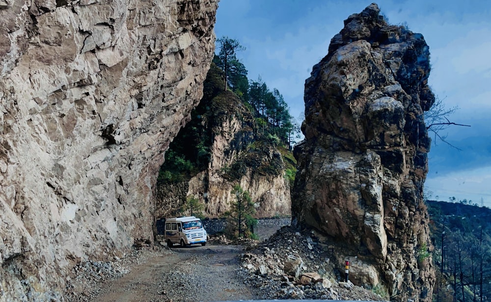 a van parked between large rocks