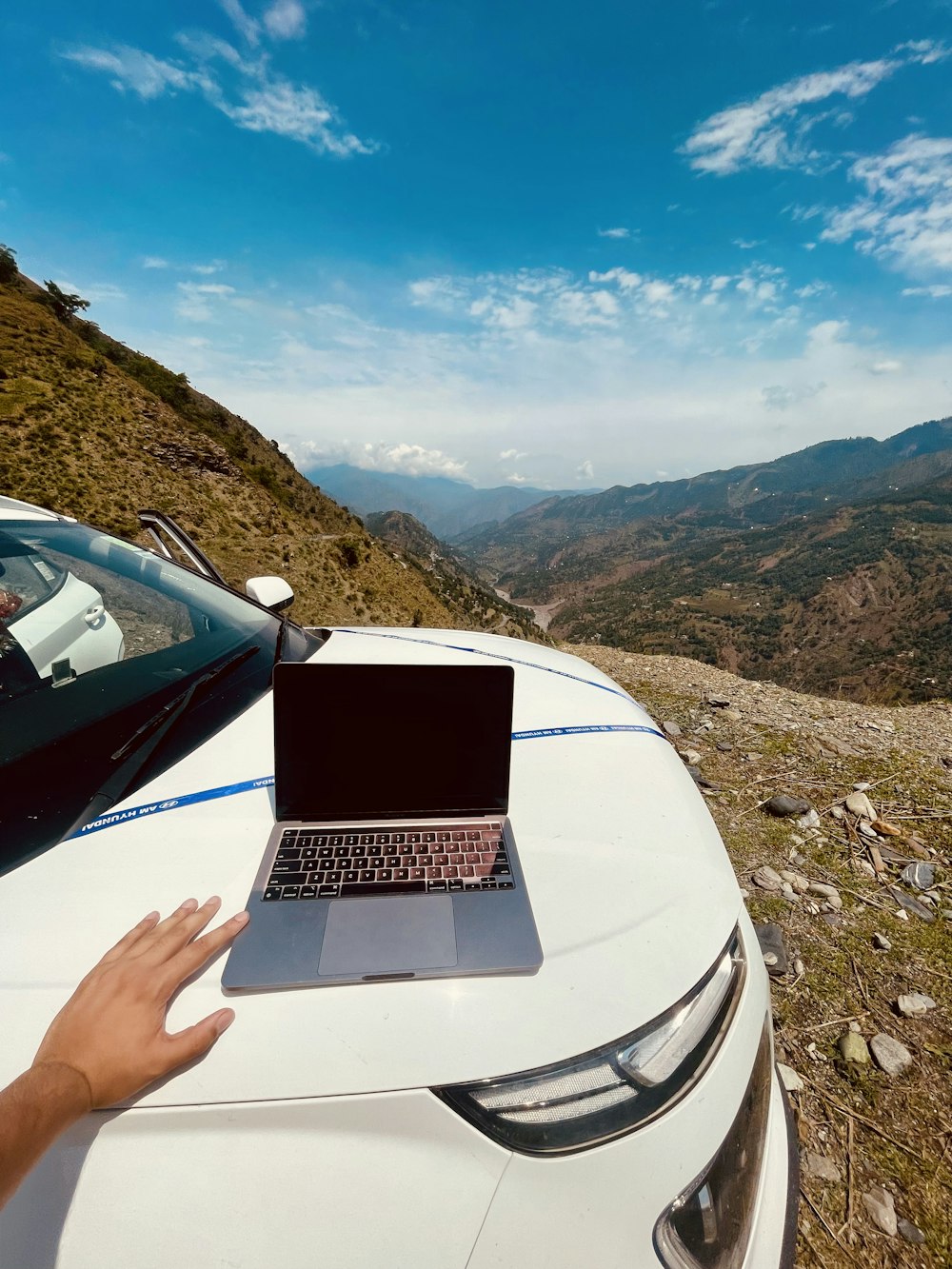 uma mão segurando um laptop em um carro