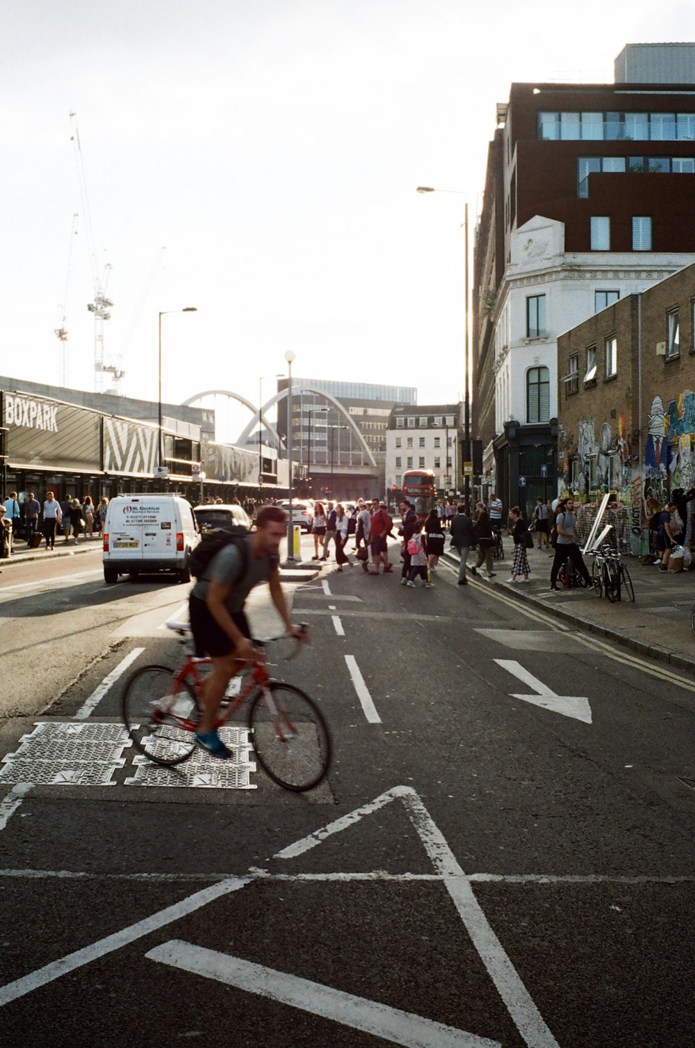 a person riding a bicycle on a street with a crowd of people