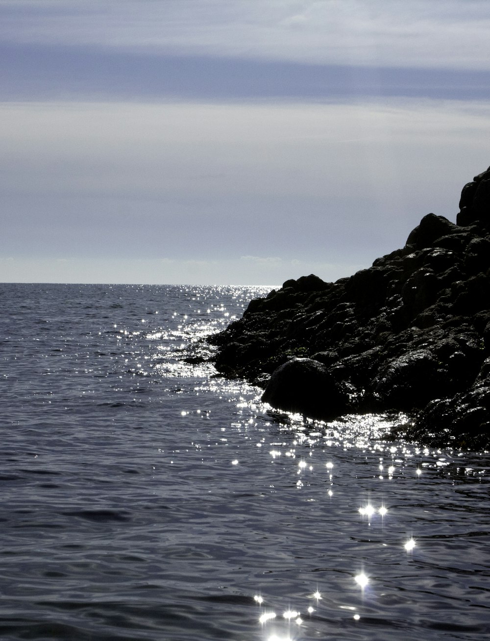 a rocky cliff next to a body of water