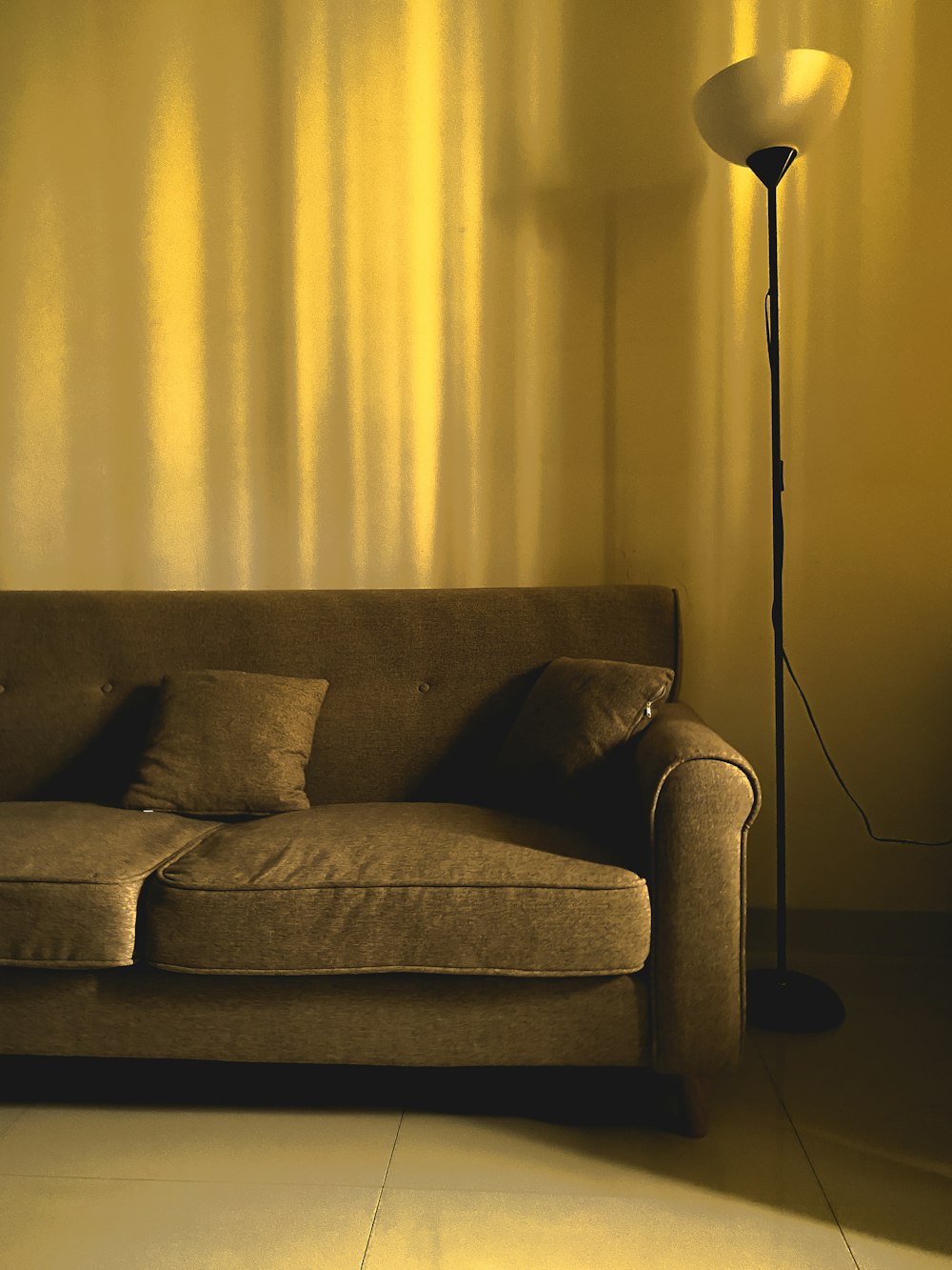 a couch with a lamp on the side