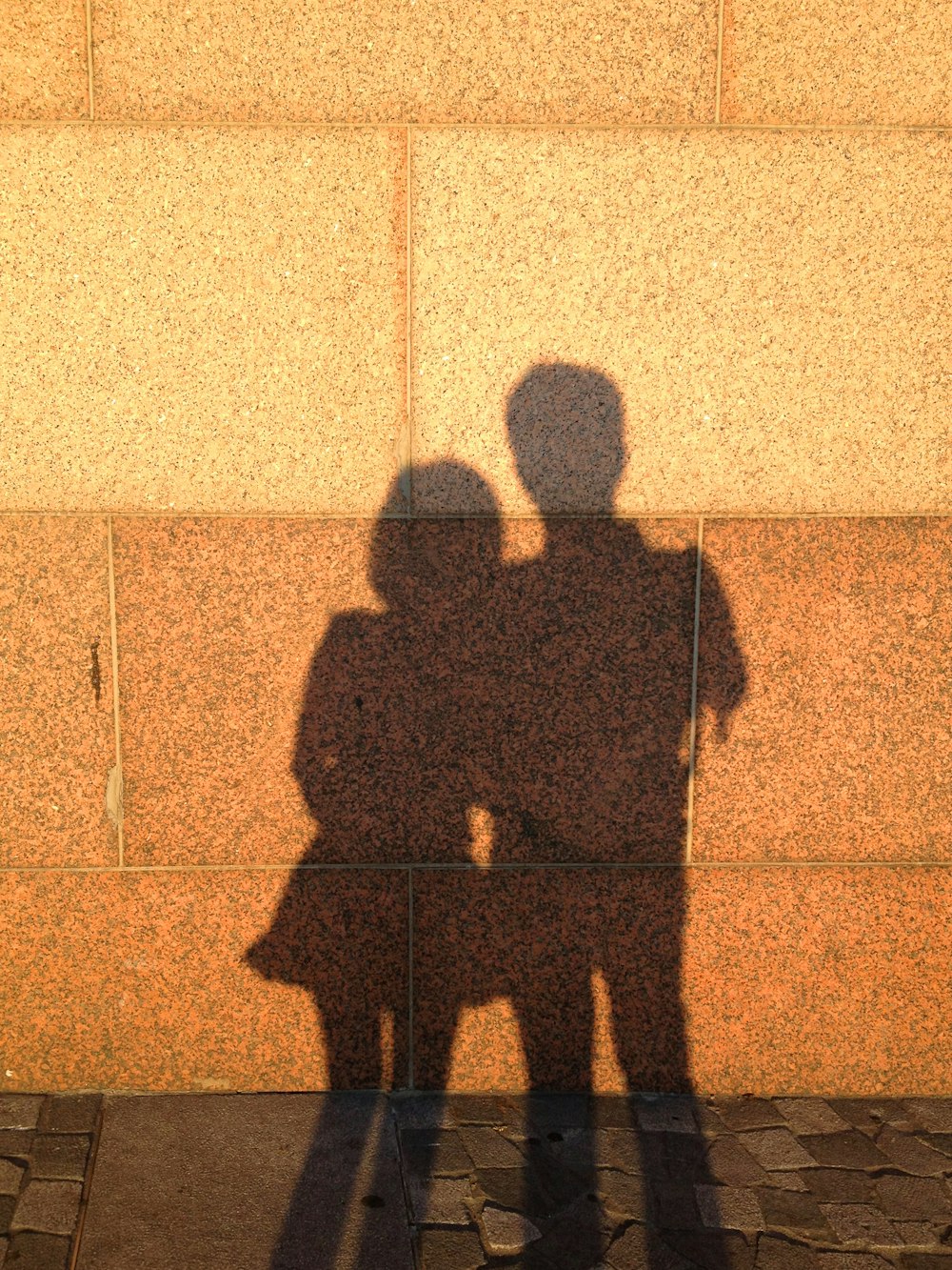 a couple of people standing in front of a wall