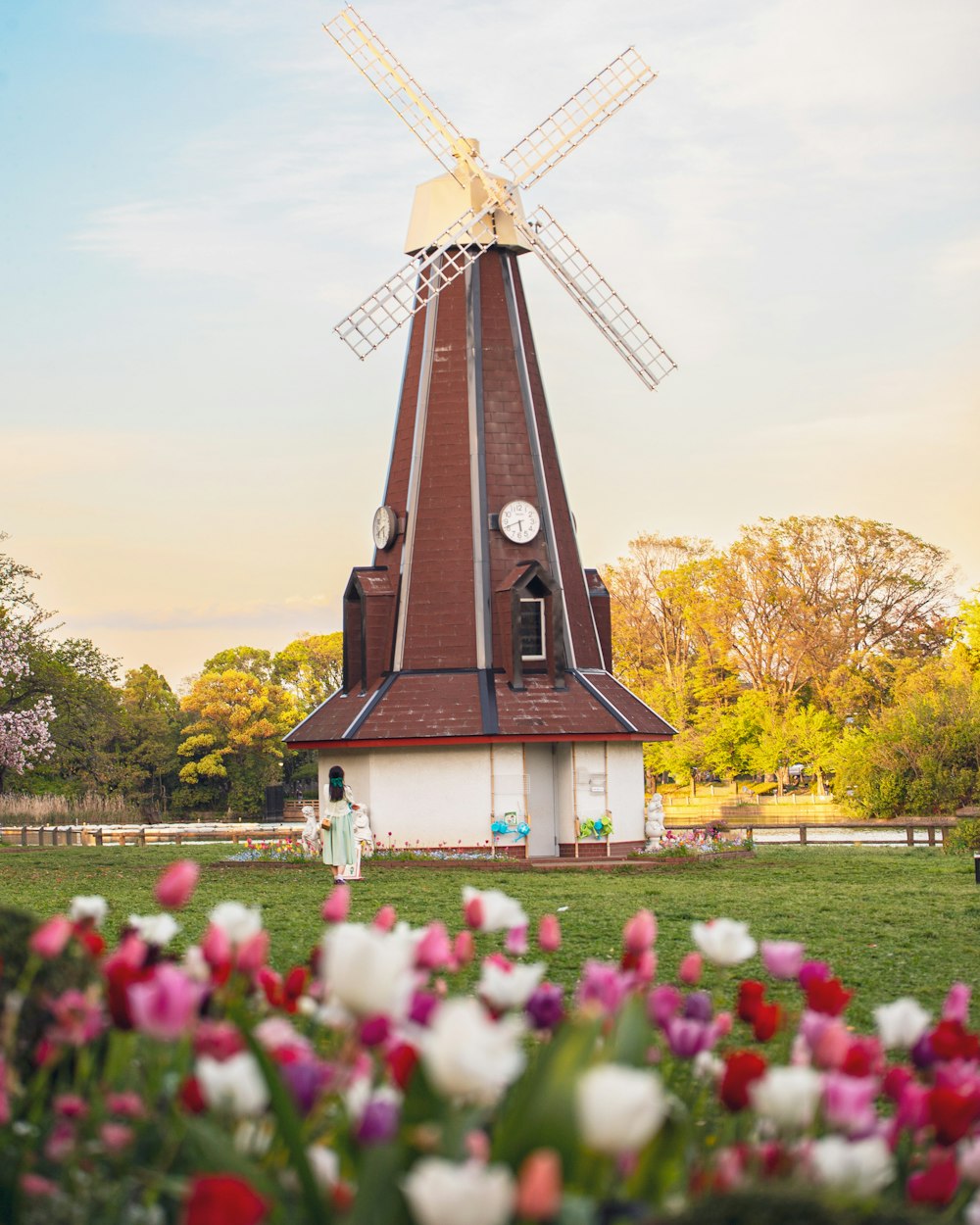 a windmill behind a field of flowers