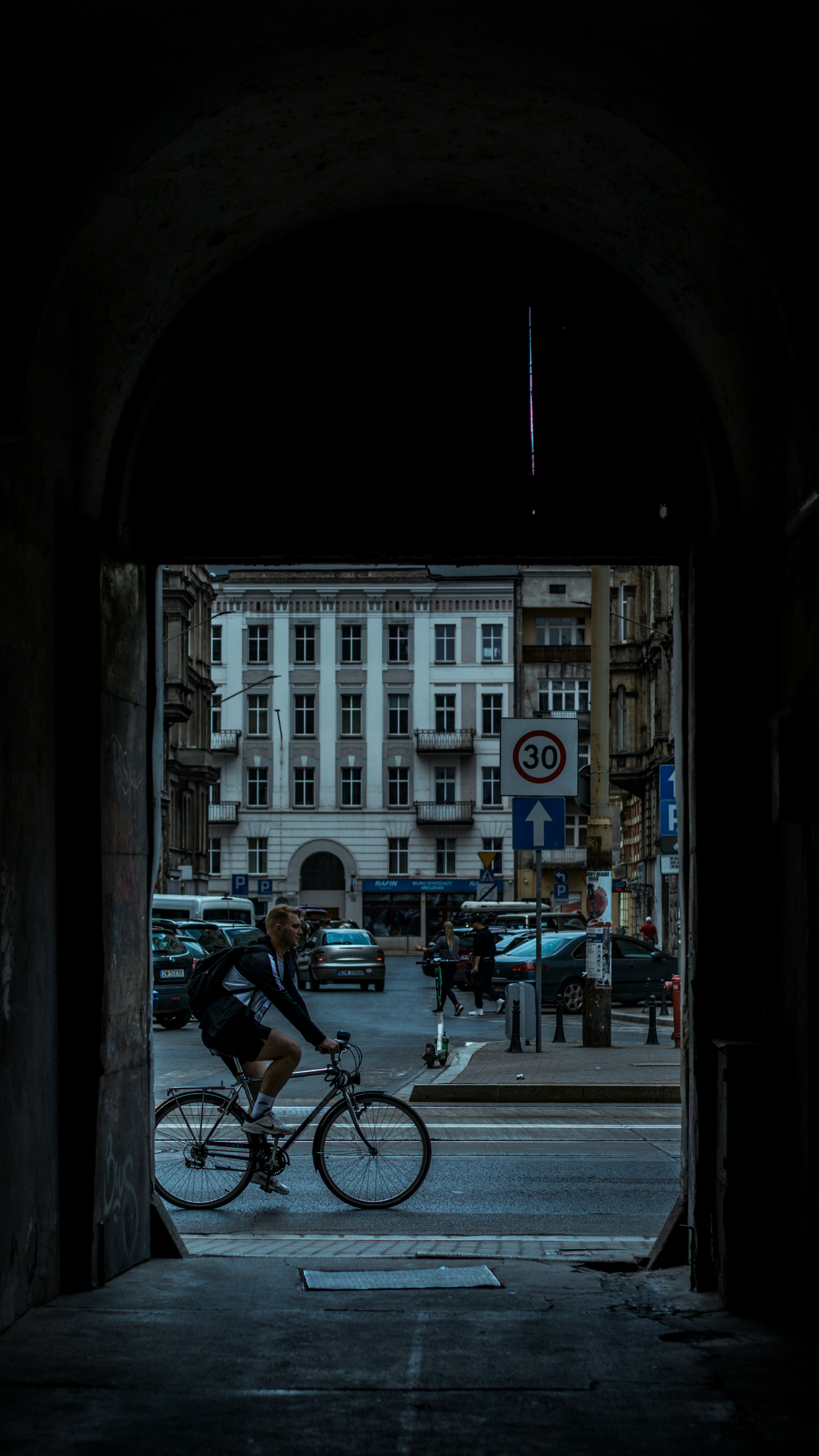 a person riding a bicycle under a bridge