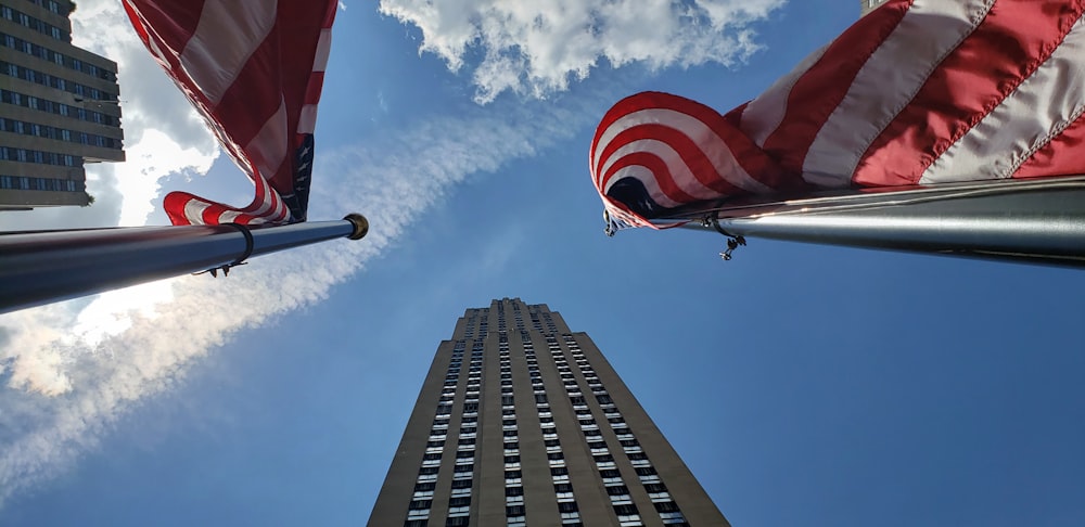 a flag flying in front of a skyscraper