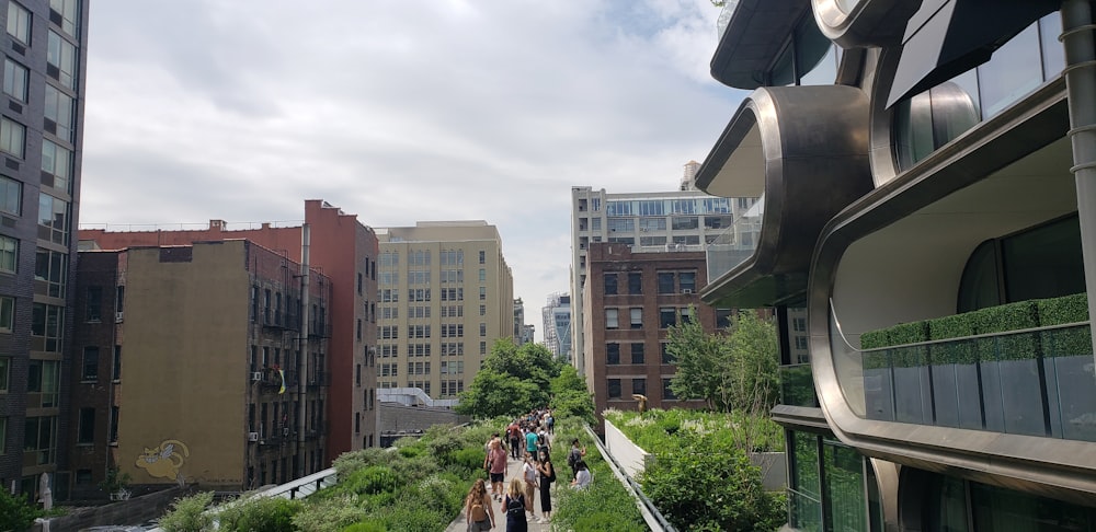 a group of people walking on a sidewalk between buildings