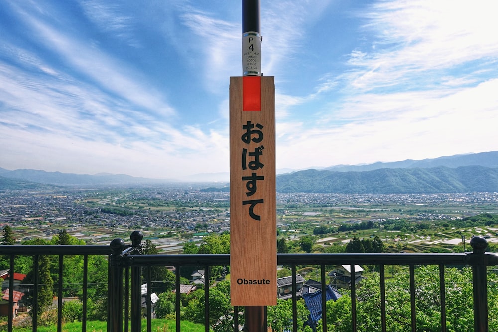 a sign on a railing overlooking a city