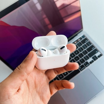 Hands holding headphones with visible USB-C charging port.