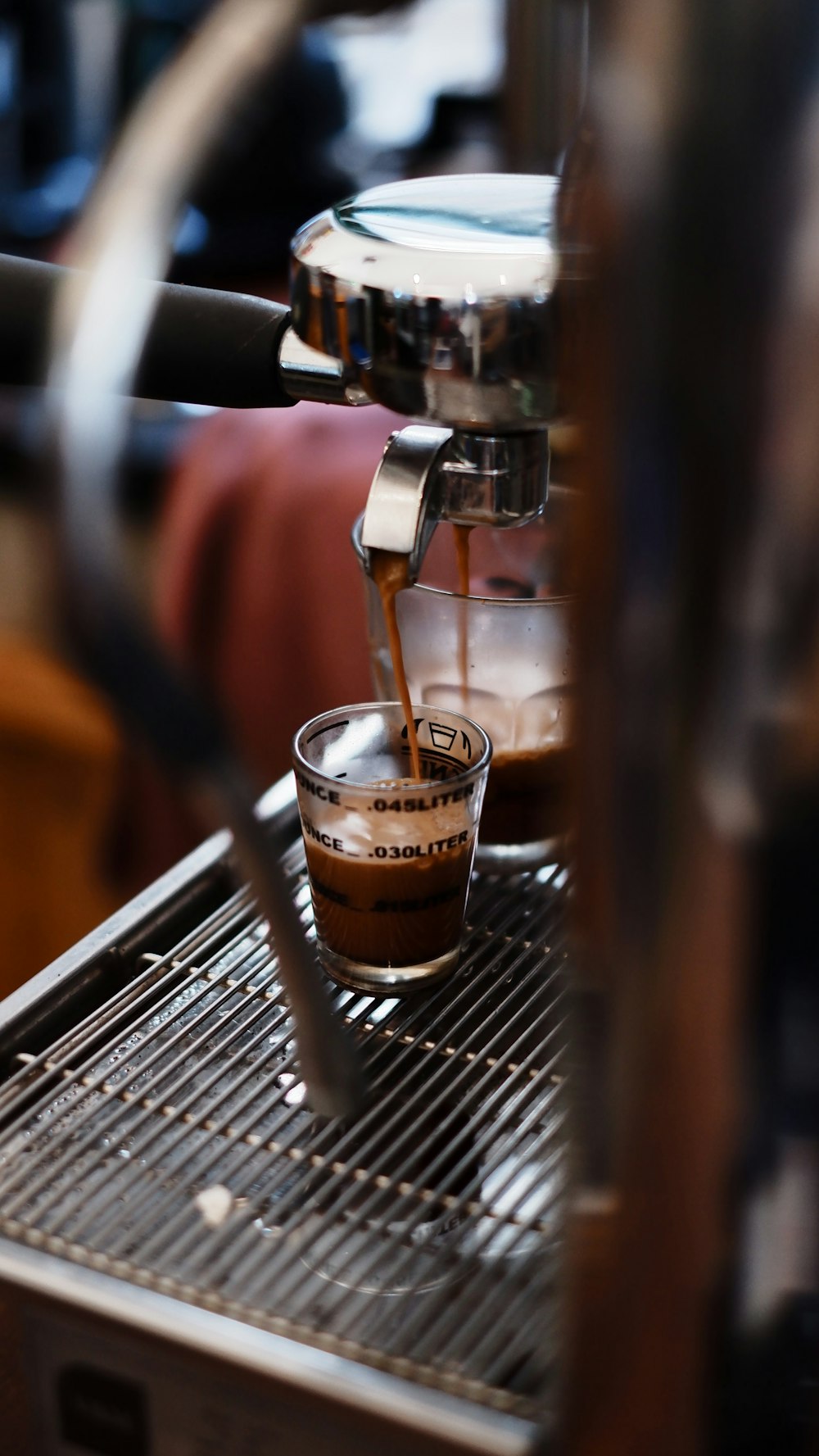 a coffee maker pouring coffee into a glass