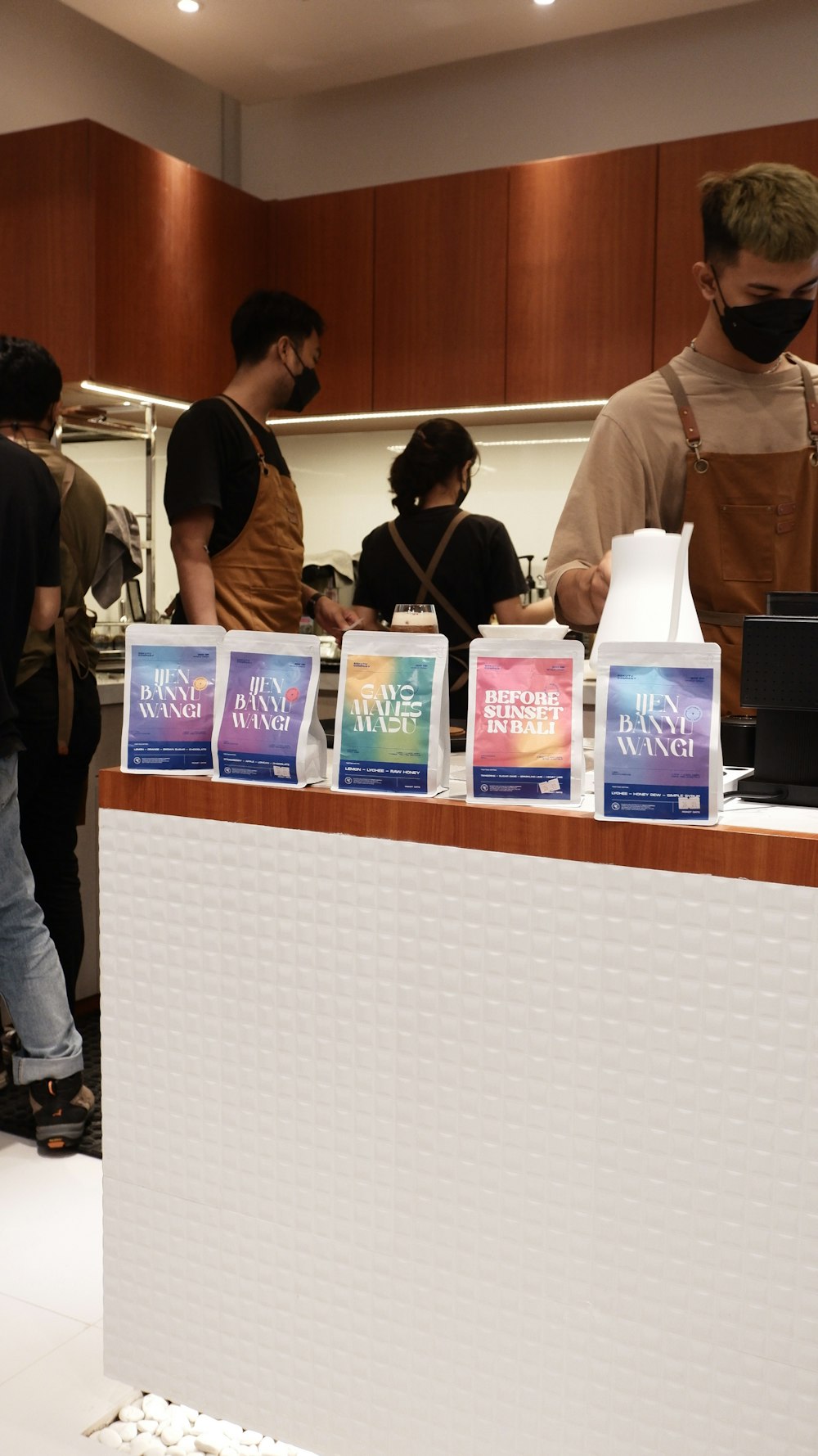 a group of people standing around a counter with books on it