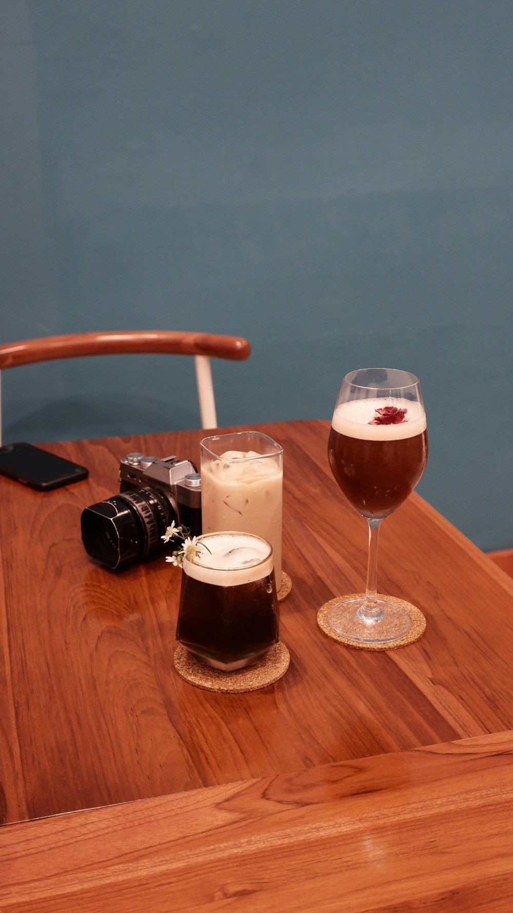 a table with glasses of beer and a camera on it