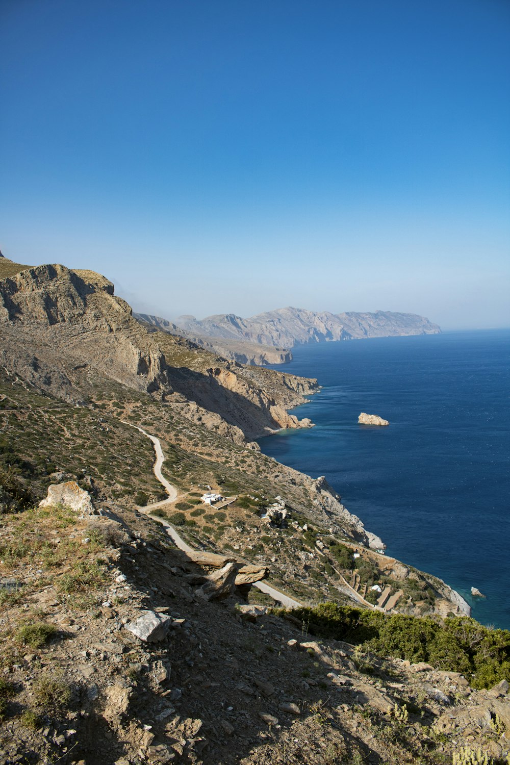 a rocky cliff next to a body of water