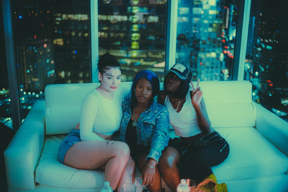 a group of people sitting on a couch posing for the camera
