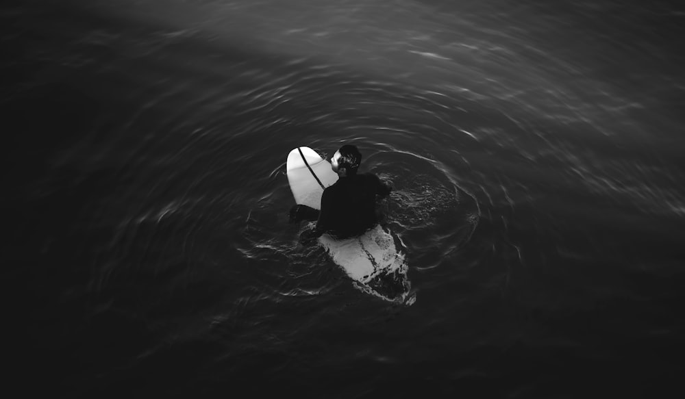 a man in the water with a surfboard