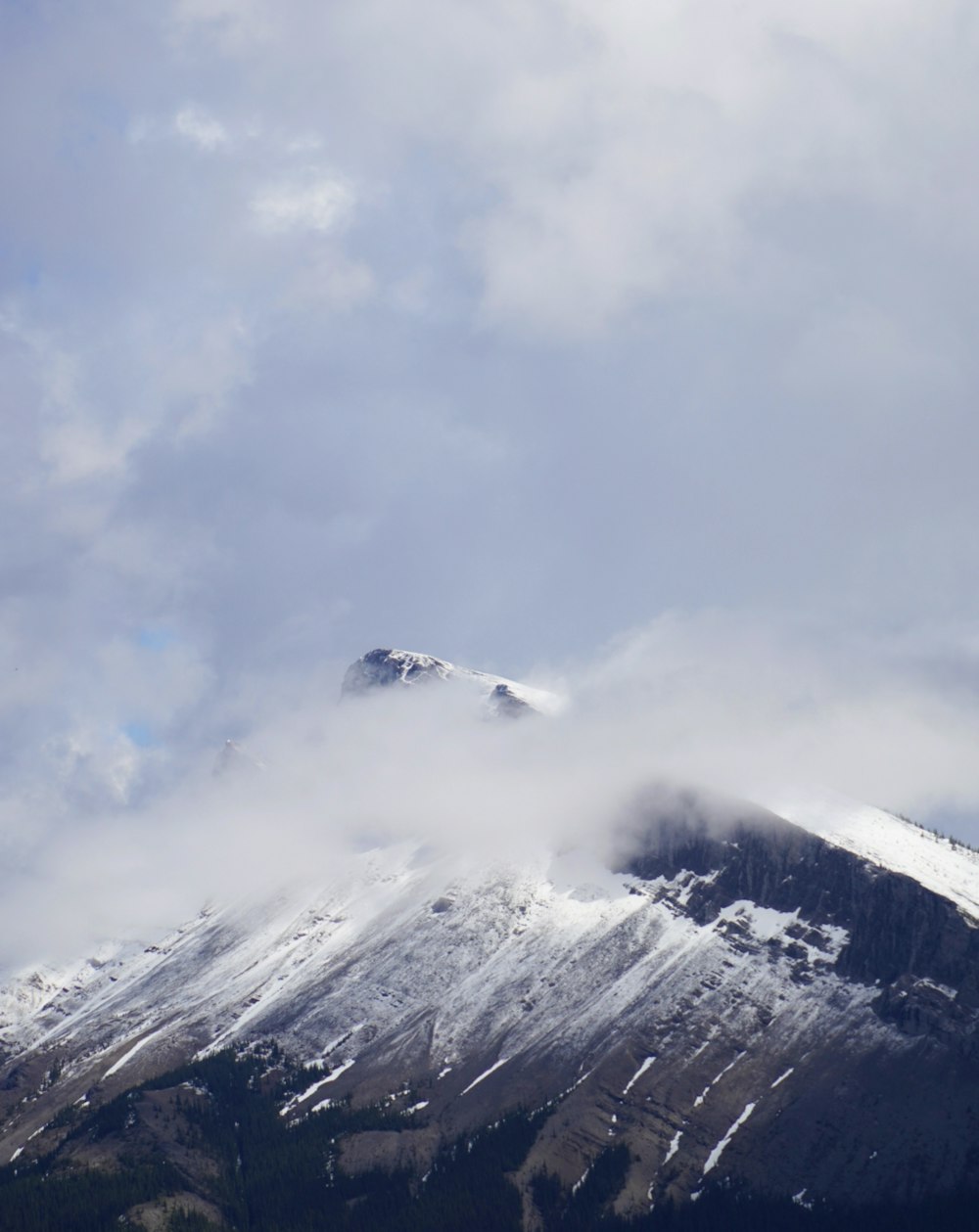 a snowy mountain with clouds