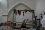 Artisan weaving a traditional Turkish scarf on a wooden loom in a cozy workshop.