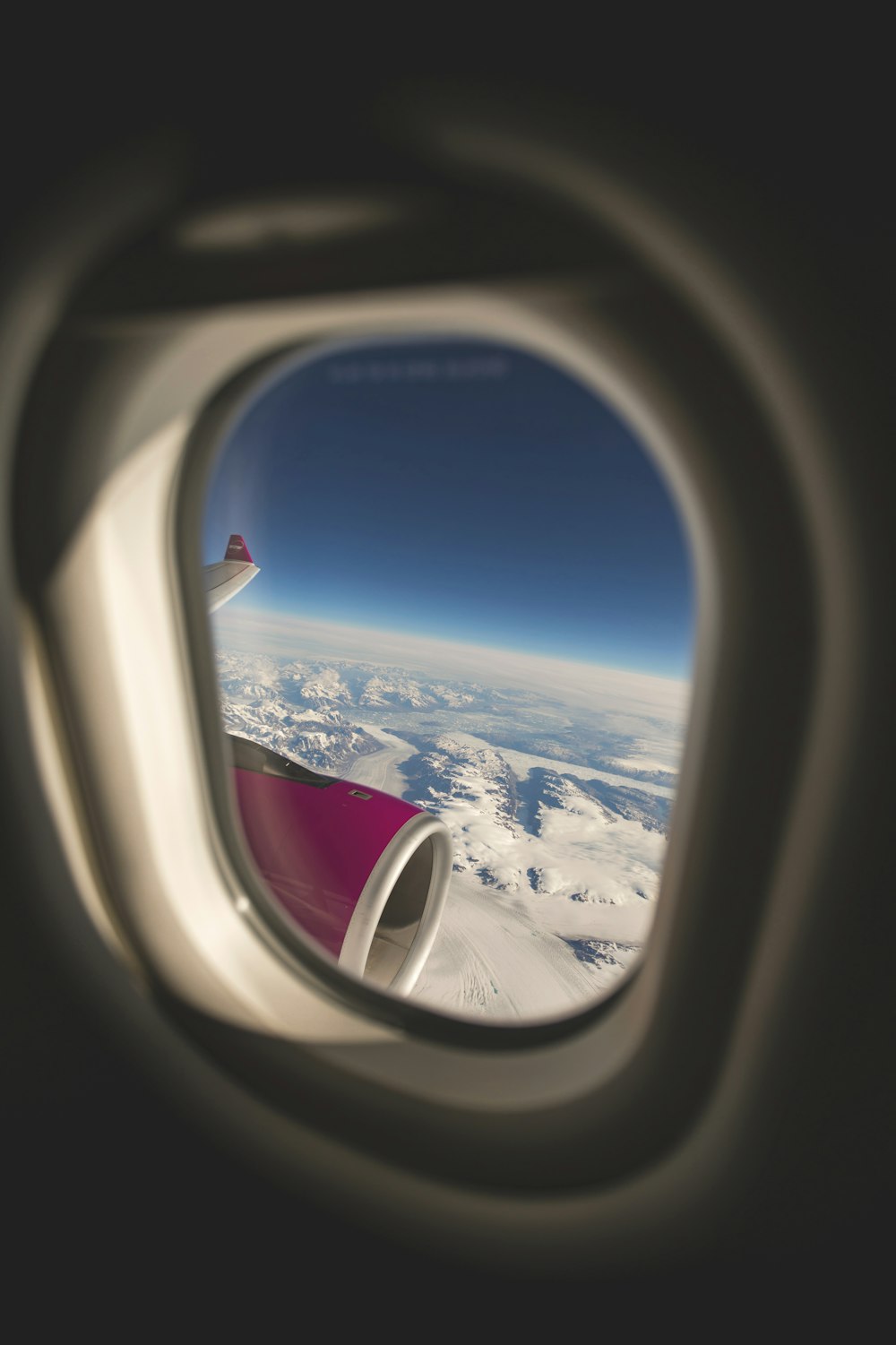 an airplane window with a view of the land below