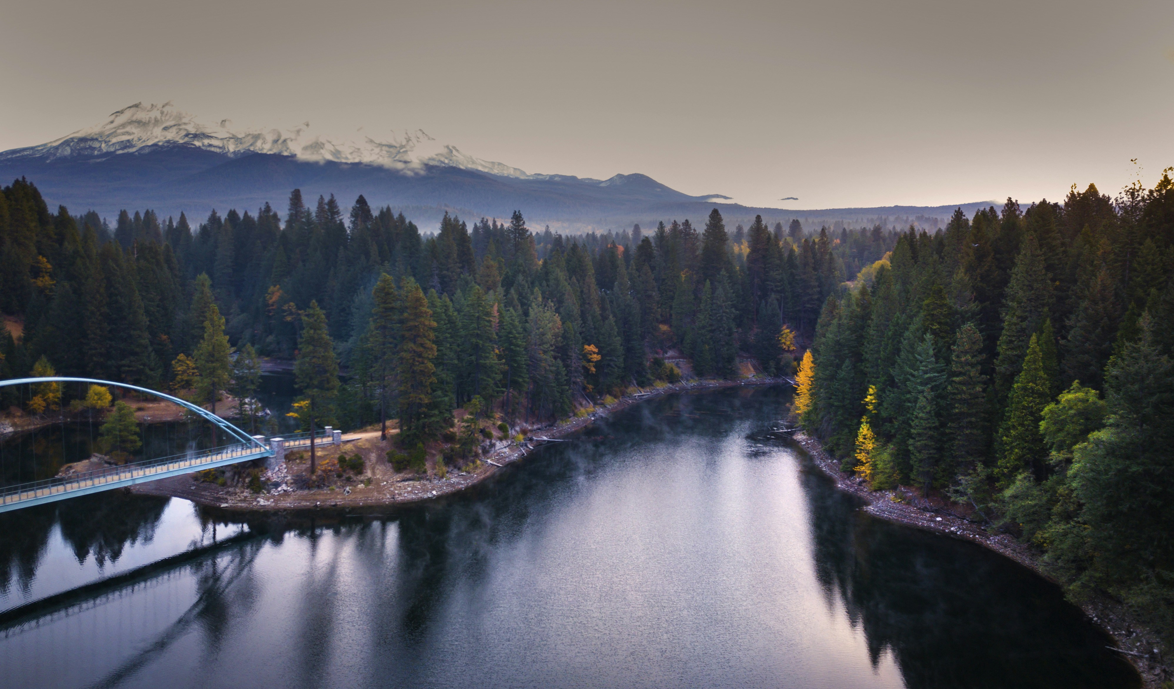A bridge over a river with trees on either side of it photo – Free Grey ...