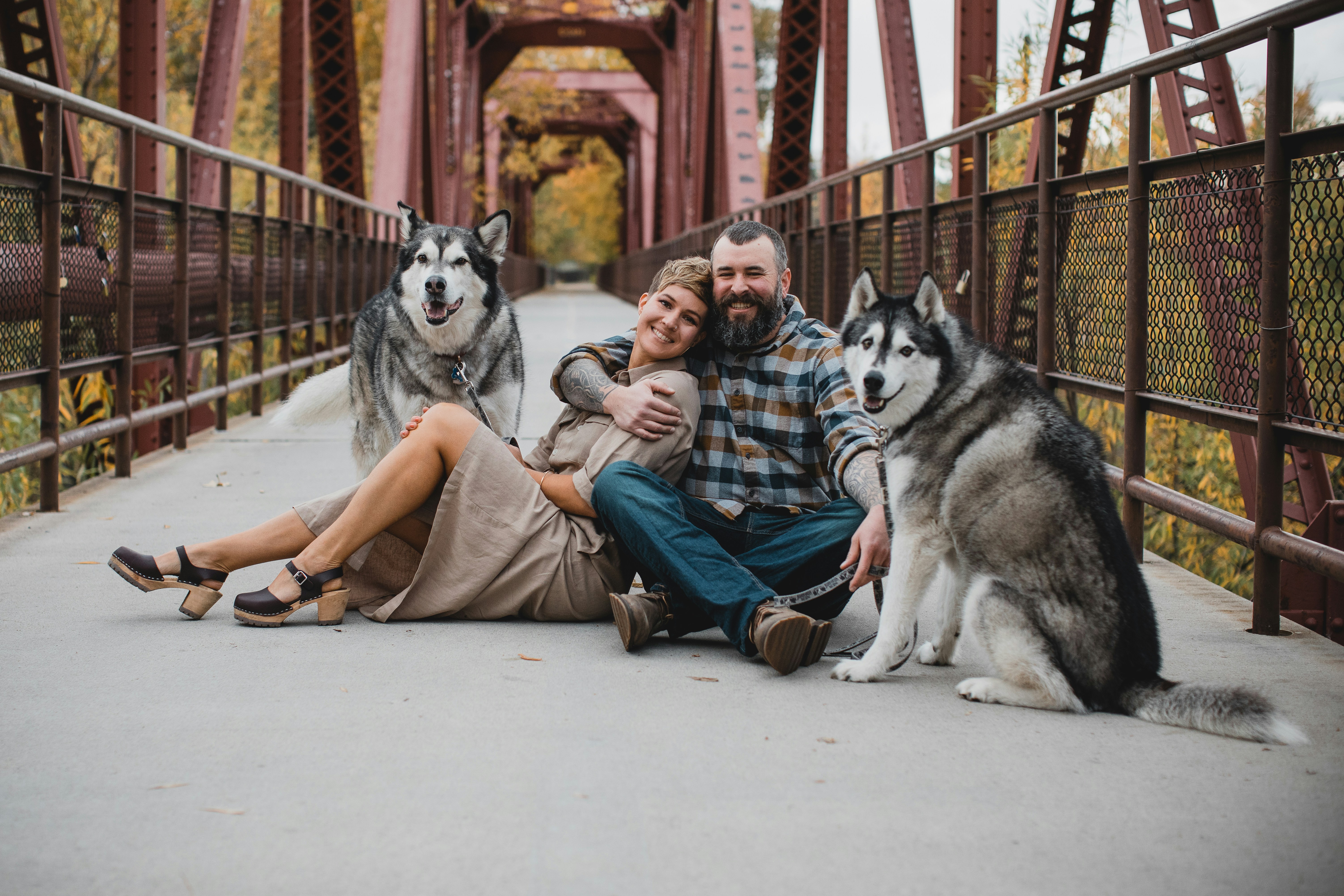 a couple of men sitting on the ground with a dog