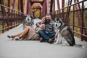 a couple of men sitting on the ground with a dog