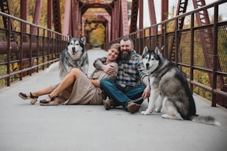 a couple of men sitting on the ground with a dog