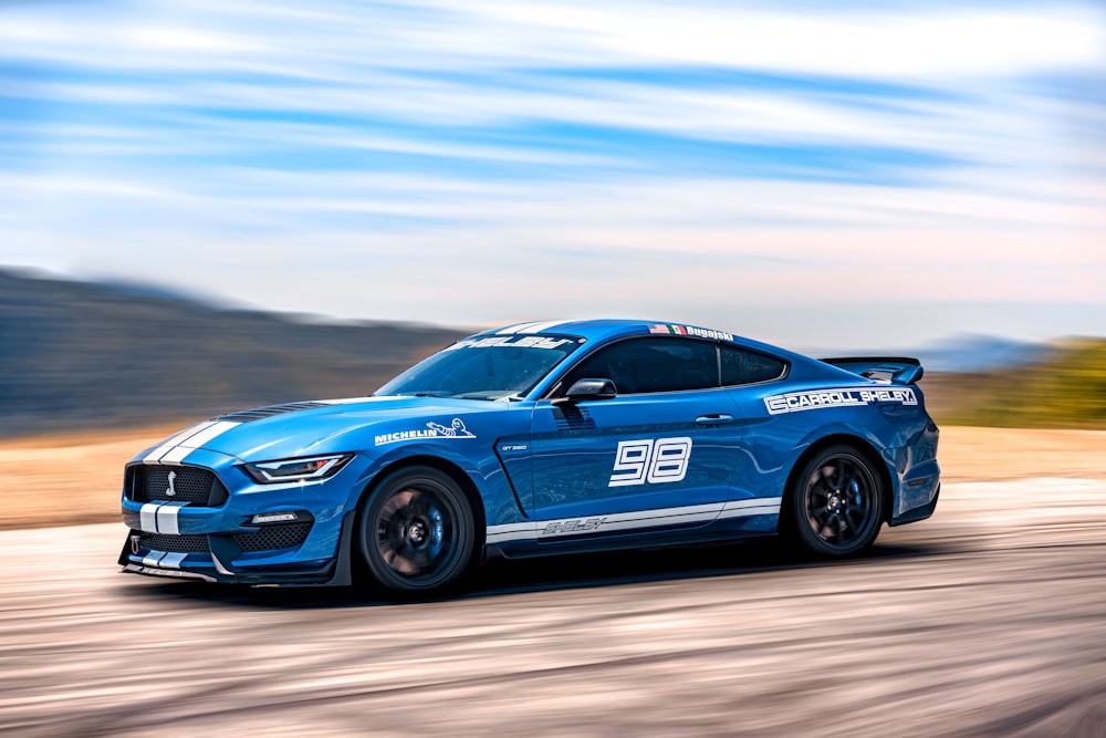 a blue car driving on a road