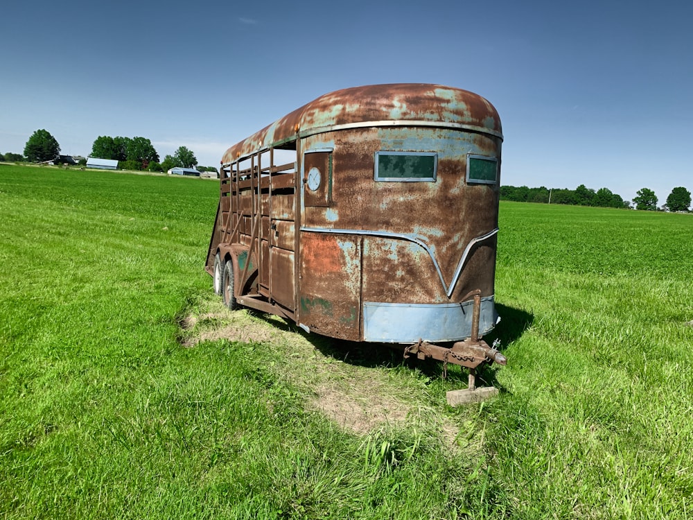 a rusty bus in a field
