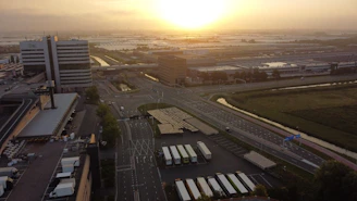 A sleek aerial view of a modern industrial park in Istanbul with golden hour lighting highlighting expansive factory plots.