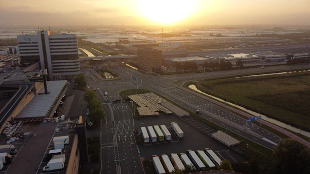 Aerial view of a sprawling industrial park at sunset with golden light highlighting warehouses.