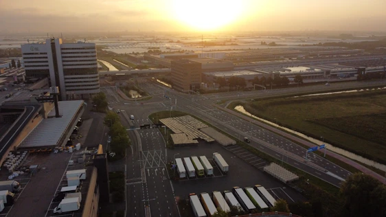 A sleek aerial view of a modern industrial park in Istanbul with golden hour lighting highlighting expansive factory plots.