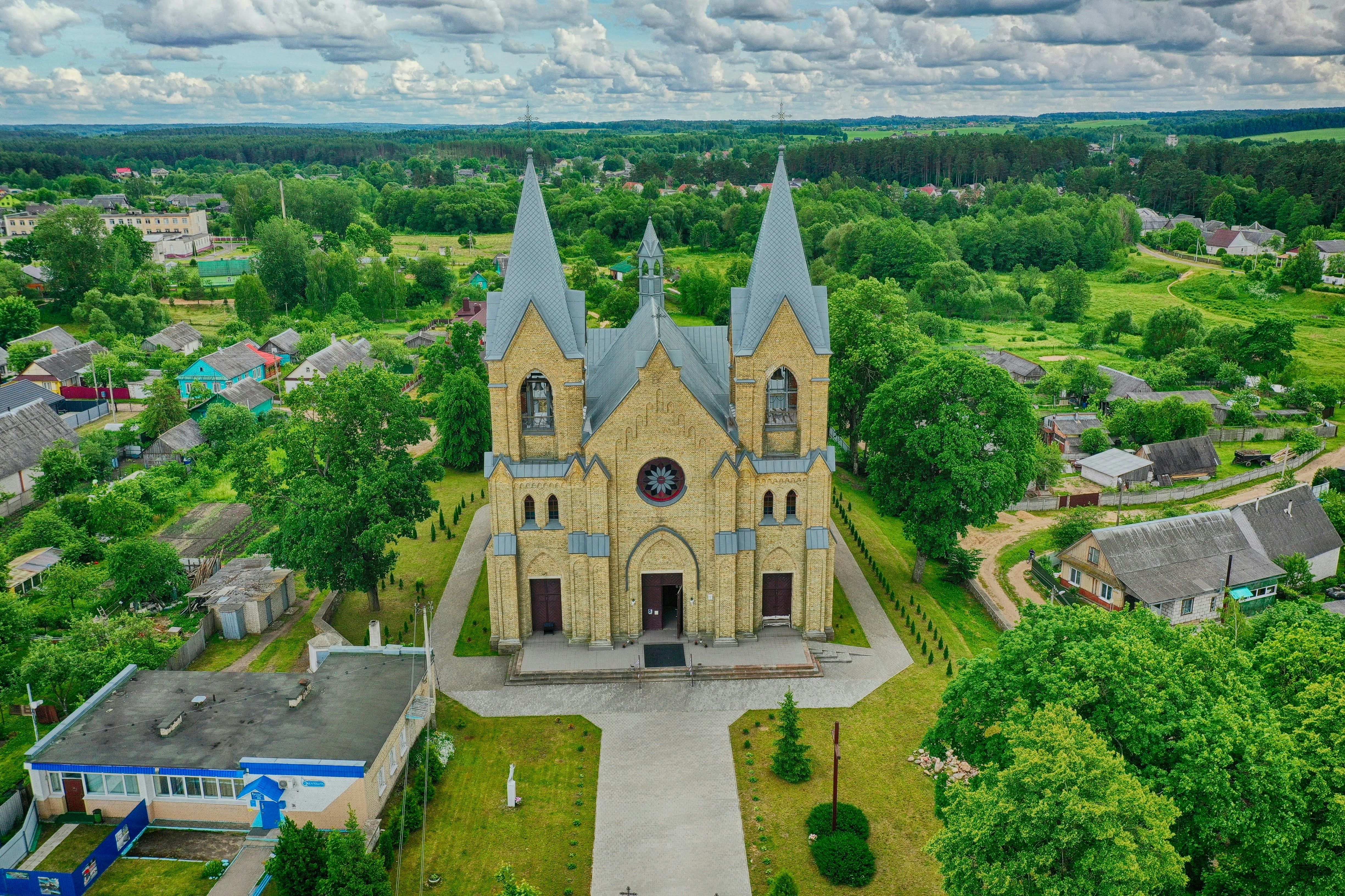 a church surrounded by trees, Костел Богоматери Руженцовой И Святого Доминика - еще один собор к копилку путешествий по Беларуси. Красивое место и весьма уникальный собор, тут не красный, а желтый кирпич, что не так часто можно встретить.